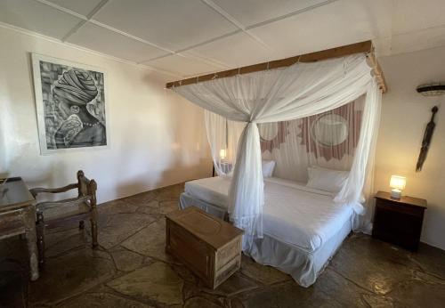 a bedroom with a bed with a canopy at Eleven Pearl Boutique Hotel & Spa in Diani Beach