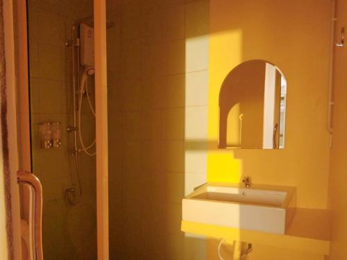 a bathroom with a sink and a mirror at Alley51 Hotel in Surat Thani