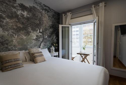 a bedroom with a large white bed and a wall mural at SF Avenue Santander in Santander
