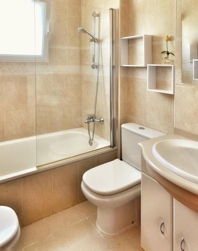 a bathroom with a toilet and a sink and a shower at Chalet Harley Denia in Denia