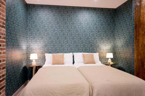 a bedroom with a large bed with a blue wall at SF Avenue Santander in Santander
