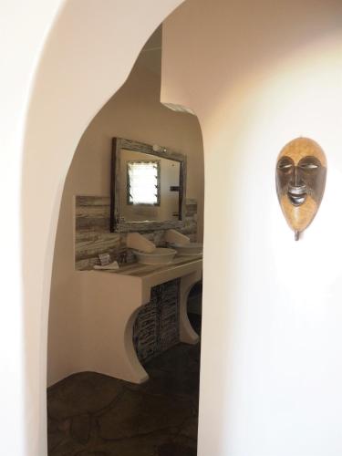 a bathroom with a sink and a mirror at Eleven Pearl Boutique Hotel & Spa in Diani Beach