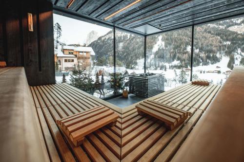 two benches in a room with a large window at Alpin Garden Luxury Maison & SPA - Adults Only in Ortisei
