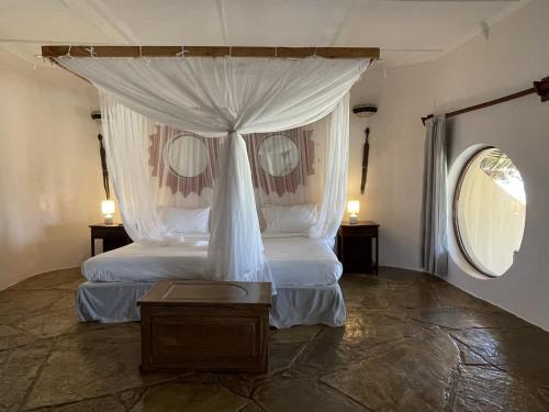 - une chambre avec un lit à baldaquin dans l'établissement Eleven Pearl Boutique Hotel & Spa, à Diani Beach
