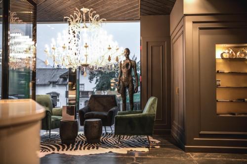 a lobby with a chandelier and a statue in the window at Alpin Garden Luxury Maison & SPA - Adults Only in Ortisei