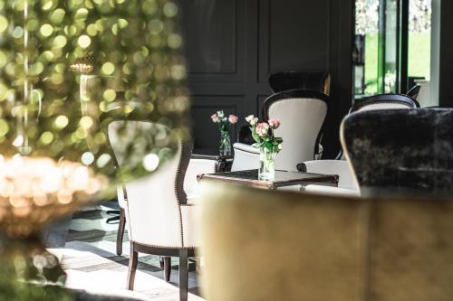 a table with chairs and a vase of flowers at Alpin Garden Luxury Maison & SPA - Adults Only in Ortisei