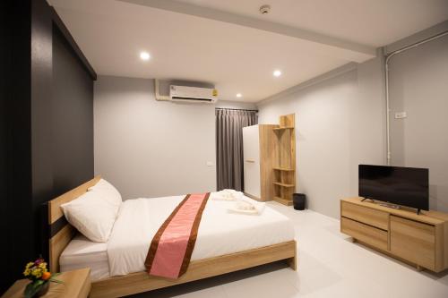a bedroom with a bed and a flat screen tv at 185@Surawong Residence in Bangkok
