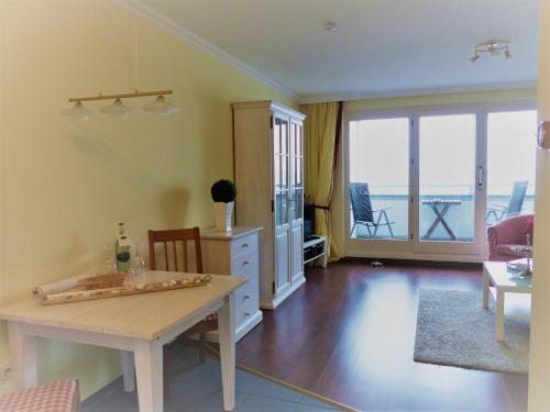 - un salon avec une table et une vue sur l'océan dans l'établissement FeWo J 24, à Laboe