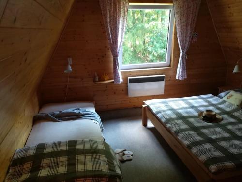 a bedroom with two beds in a log cabin at Chata pod lesem in Rýmařov