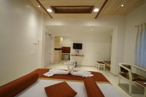 a bedroom with a bed with a towel on it at Hotel Palmyra Grand Inn in Tirunelveli