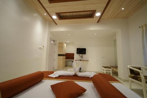 a bedroom with a bed and a living room at Hotel Palmyra Grand Inn in Tirunelveli