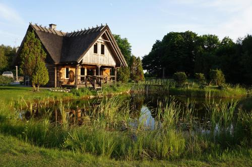 a house with a pond in front of it at Mardi Farm Stay in Karala