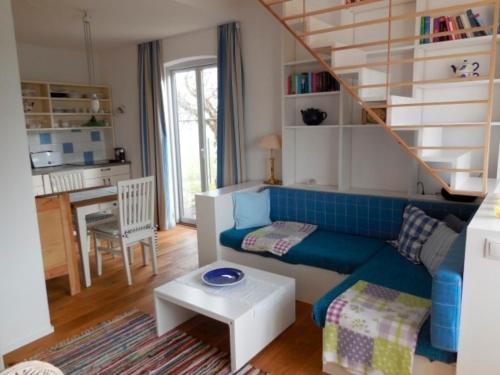 a living room with a blue couch and a staircase at Ferienhaus Schwille - Loft 2 in Westerbergen