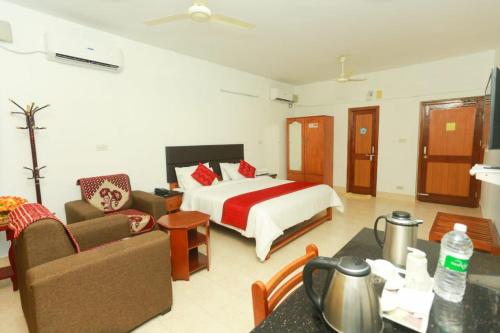a hotel room with a bed and a living room at KTDC Tamarind Kondotty in Kondotti