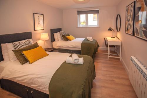two beds in a small room with a desk and a bed at Apartment 293 - Clifden in Clifden