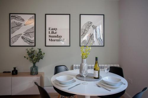 a dining room with a white table with a bottle of wine at Apartment 293 - Clifden in Clifden