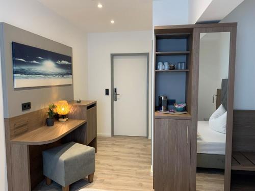 a room with a desk and a bedroom with a bed at Gästehaus freches Perlhuhn in Blumenthal