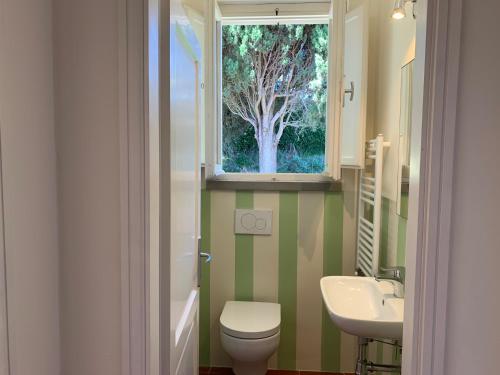 uma casa de banho com um lavatório, um WC e uma janela. em Spectacular Chianti View close San Gimignano em Tavarnelle in Val di Pesa