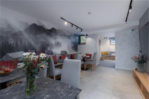una sala da pranzo con un tavolo con sopra dei fiori di Villa 7 Apartments a Zakopane