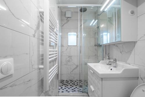 a white bathroom with a sink and a mirror at Logement entier à Paris in Paris