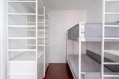 Cette chambre dispose d'étagères blanches et de lits superposés. dans l'établissement Logement entier à Paris, à Paris