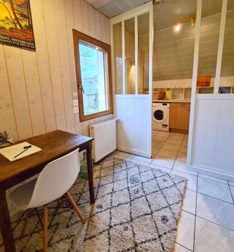 a kitchen with a wooden table and a table and chair at Les Gîtes du Goelo in Plouha