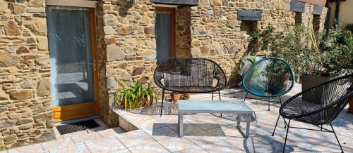 three chairs and a table in front of a building at Les Gîtes du Goelo in Plouha