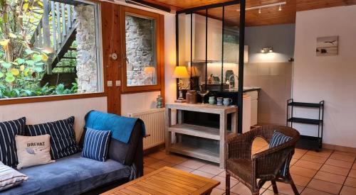 a living room with a blue couch and a table at Les Gîtes du Goelo in Plouha