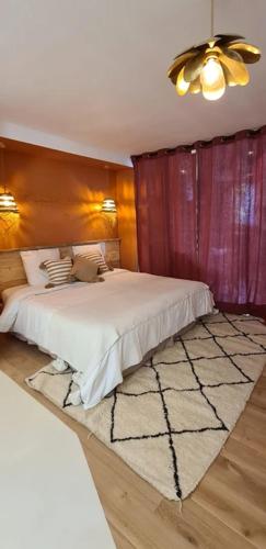 a bedroom with a white bed and a rug at Les Gîtes du Goelo in Plouha