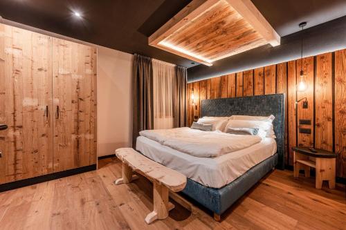 a bedroom with a large bed and wooden walls at Nidaris - Luxury Private Spa Suites in Malè