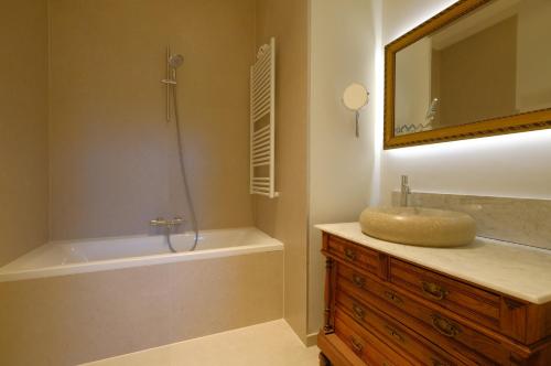 een badkamer met een wastafel, een bad en een spiegel bij La Maison de la Duchesse de la Vallière - Parking privé gratuit in Bergen