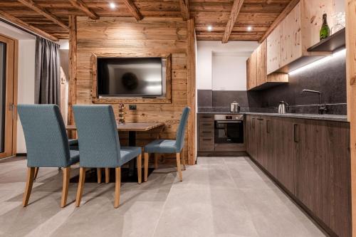 a kitchen with a table and chairs and a tv at Nidaris - Luxury Private Spa Suites in Malè