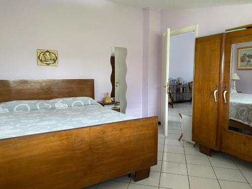 a bedroom with a large wooden bed and a door at Villa Ulivi in Tocco da Casauria