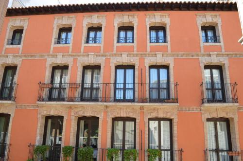 an orange building with windows and balconies at Casa Palacio de los Sitios in Zaragoza