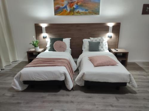 a bedroom with two beds and two tables and a painting at PincoPancoRooms in Acquasanta Terme