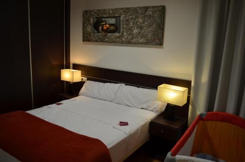 a hotel room with a bed and two lamps at Casa Palacio de los Sitios in Zaragoza