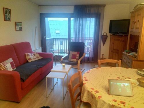 ein Wohnzimmer mit einem Sofa und einem Tisch mit einem Laptop in der Unterkunft Residence Pierre Aigue in Saint-Sorlin-dʼArves
