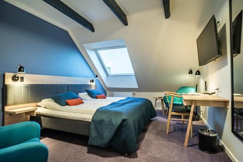 Schlafzimmer mit einem Bett, einem Tisch und Stühlen in der Unterkunft Hotel Allinge in Allinge