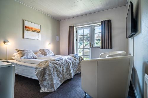 a hotel room with a bed and a window at Hotel Allinge in Allinge