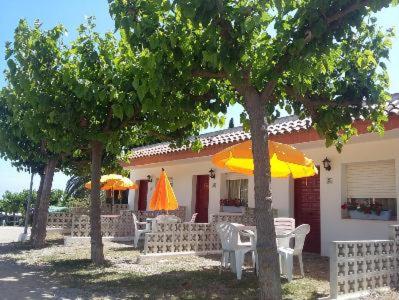 a house with tables and chairs and umbrellas at Camping Cambrils Caban in Cambrils
