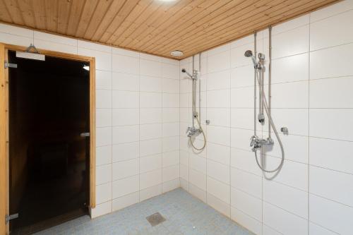 a bathroom with a shower stall and a door at Hotelli Selli in Vihti