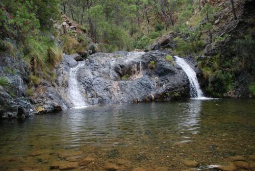 a waterfall in the middle of a pool of water at La Posada del Recovero in Genalguacil
