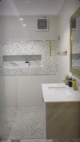a white bathroom with a sink and a mirror at استراحة ريف حتا in Hatta