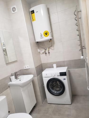 a bathroom with a washing machine and a sink at Apart Ugorska in Lviv