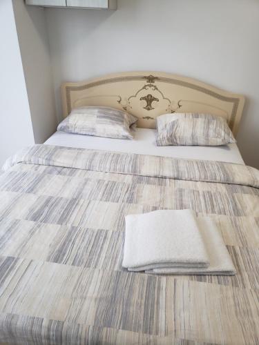 a bed with two pillows and a blanket on it at Apart Ugorska in Lviv