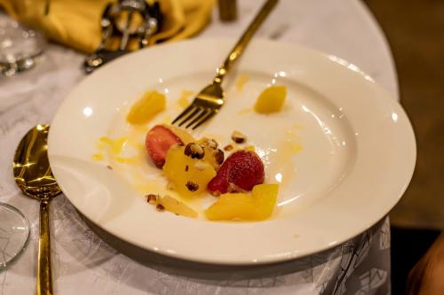 a plate of food with fruit on a table at Gordonsville Escape Boutique Hotel in Port Harcourt