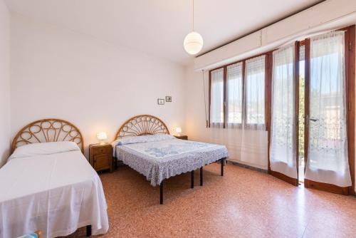 una camera da letto con due letti e una grande finestra di Suite Daniela 3 by MMega a Massa