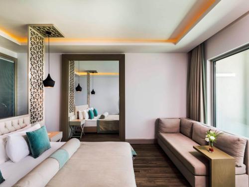 a living room with a couch and a bed at Blue Dreams Resort Bodrum - Aquapark & Ultra All Inclusive in Torba