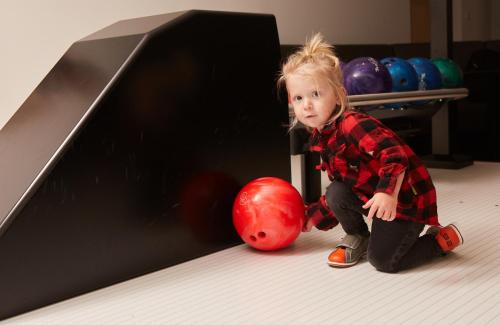 a little girl playing with a red bowling ball at Appartement & Suiten Hotel Glöcknerin in Obertauern