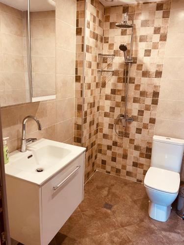 a bathroom with a toilet and a sink and a shower at Къща край реката/ House by the river in Vetrintsi
